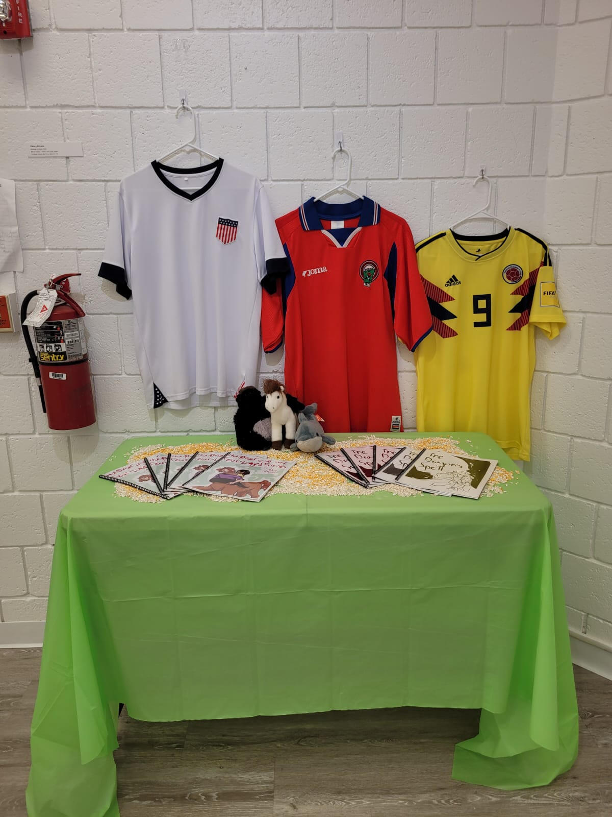 Homage to Roots, 2023, installation with comics, table, uniforms, mixed media, comics: 8" × 11", installation: dimensions variable